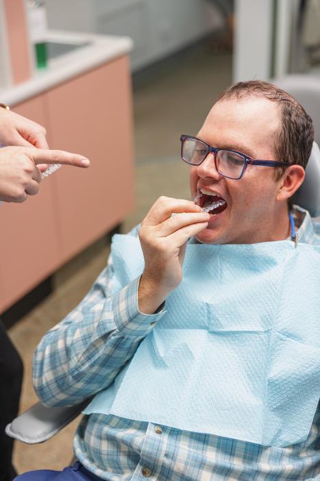 A patient putting in his Invisalign tray